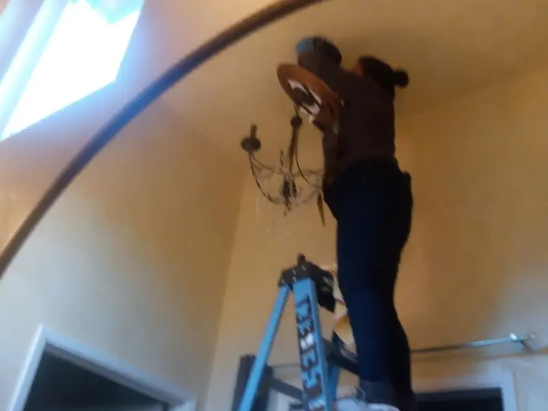 Electrician installing a chandelier in a Watergate residence